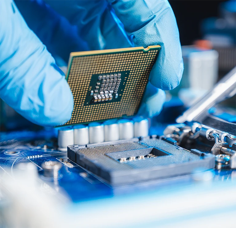 Gloved hand placing a computer chip in it's socket